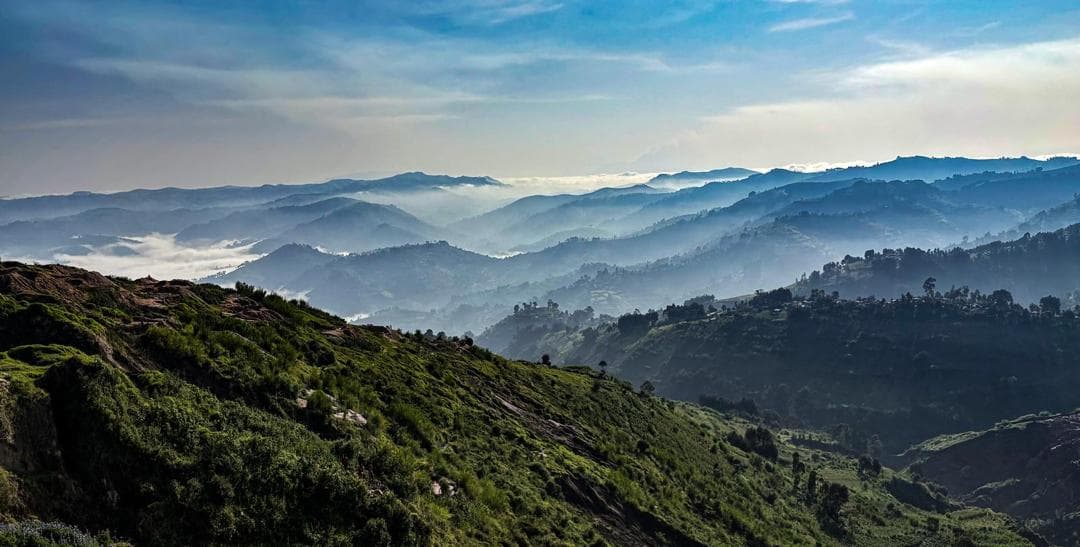 Mist-filled valleys and green hills at sunrise in the Kivu highlands